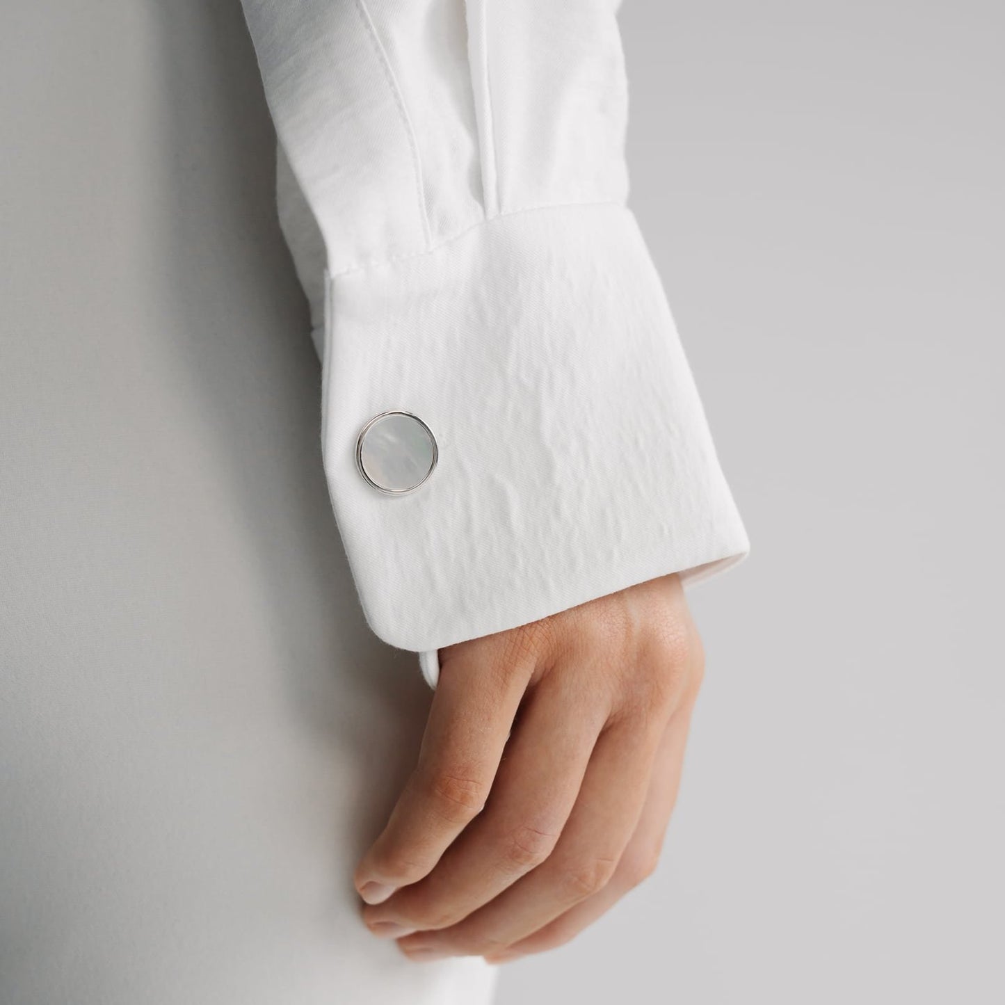 A woman wears her timeless My Planet Cufflinks features our Cygnet Bay (WA) Australian South Sea Mother of Pearl shell set in Sterling Silver.