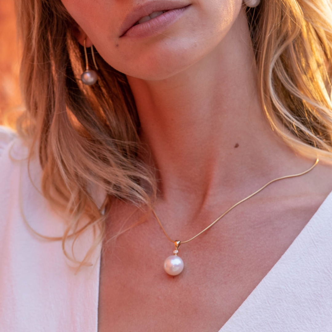 A woman wears her Nivea Pearl Pendant featuring a Cygnet Bay (NSW) grown Australian South Sea Pearl with a White Diamond set in gold.