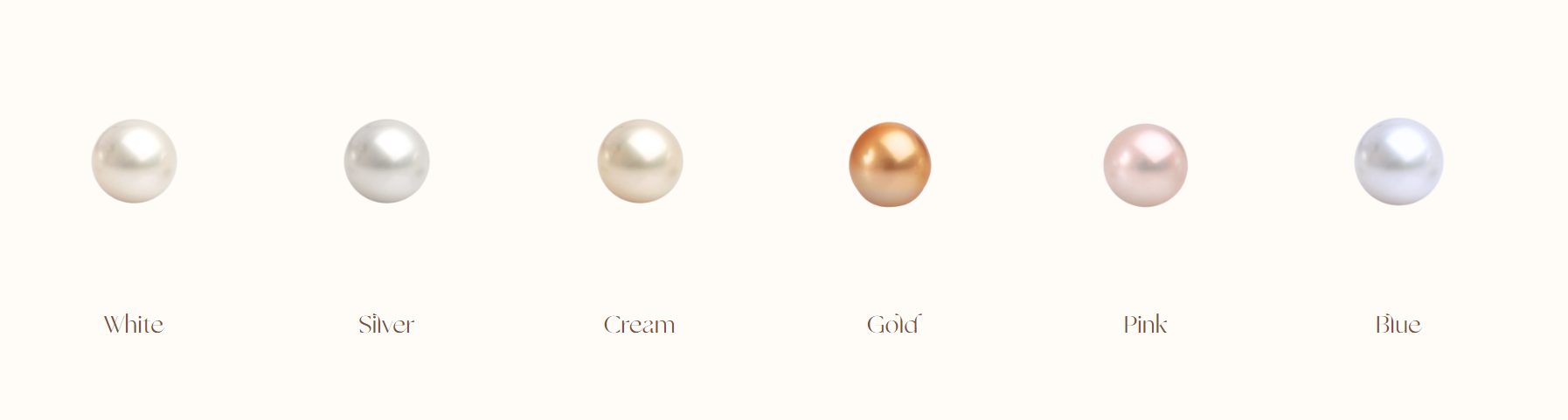 A row of pearls sorted in colour order, from white, to silver, to cream, then gold, pink and finally blue. Showcasing the array of colours that our pearls can come in.