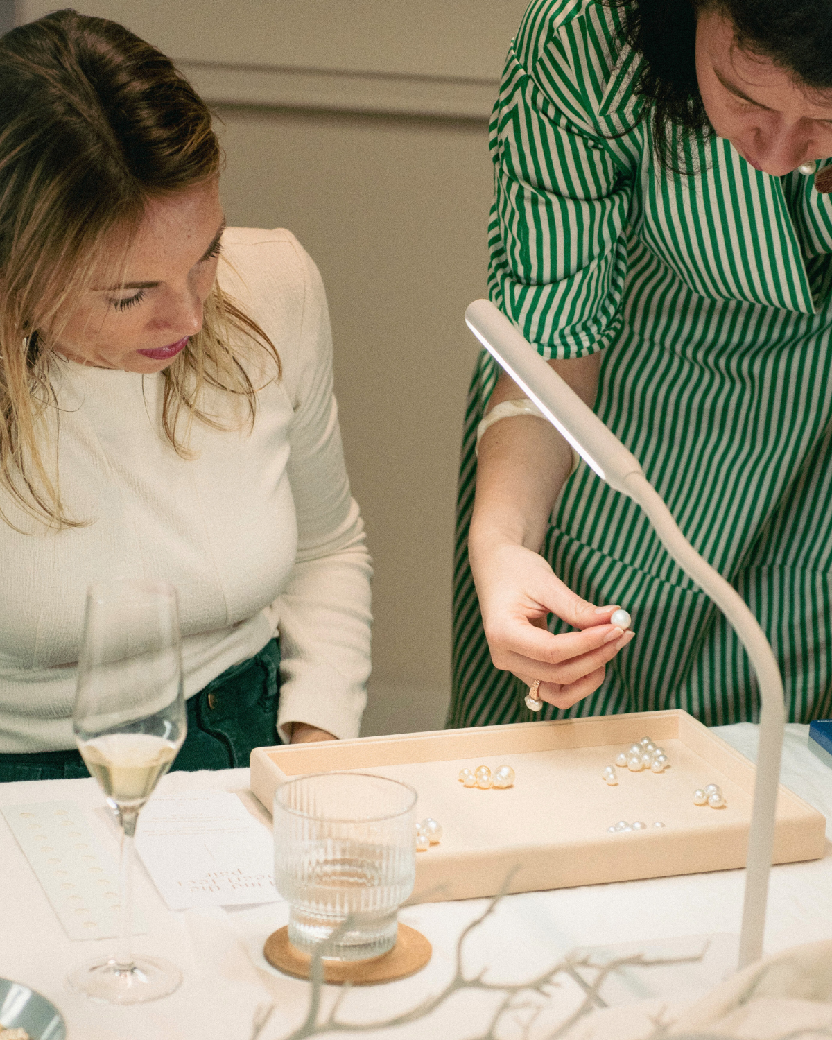 A pearl expert shows her guest a stunning Australian South sea pearl at our Pearl Masterclass, with a tray of stunning Australian pearls showcased.