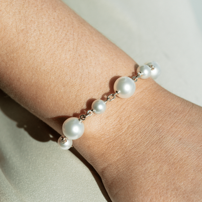 A woman wears her incredible Provenance Pearl Strand Bracelet features two Cygnet Bay (WA) grown Australian South Sea pearls alongside four Broken Bay (NSW) grown Australian Akoya pearls set on a gold chain.