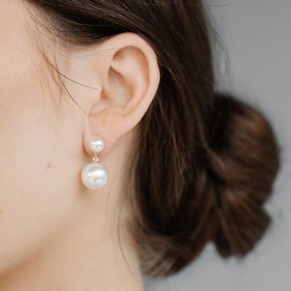 A woman wears her Provenance Short Pearl Earrings features a Cygnet Bay (WA) grown Australian South Sea pearl and two Broken Bay (NSW) grown Australian Akoya pearls set in gold.