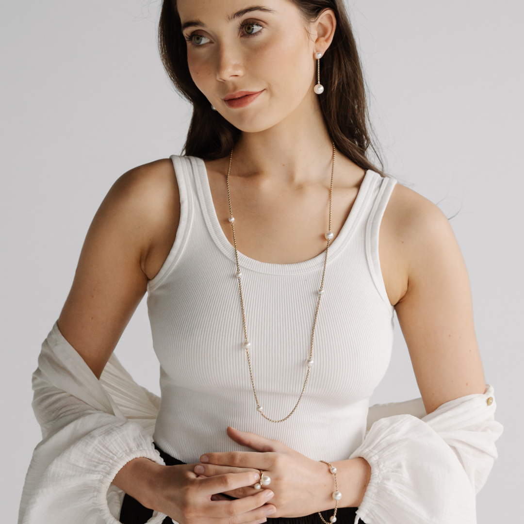 A woman wears her incredible Provenance Pearl Necklace features three Cygnet Bay (WA) grown Australian South Sea pearls and four Broken Bay (NSW) grown Australian Akoya pearls set on a 90cm gold chain.