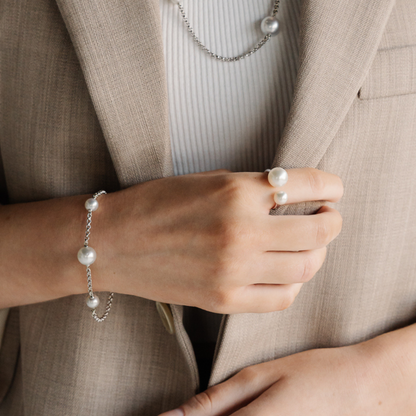 A person wears their Provenance Open Pearl Ring features a Cygnet Bay (WA) grown Australian South Sea pearl alongside a Broken Bay (NSW) grown Australian Akoya pearl set on a gold band.