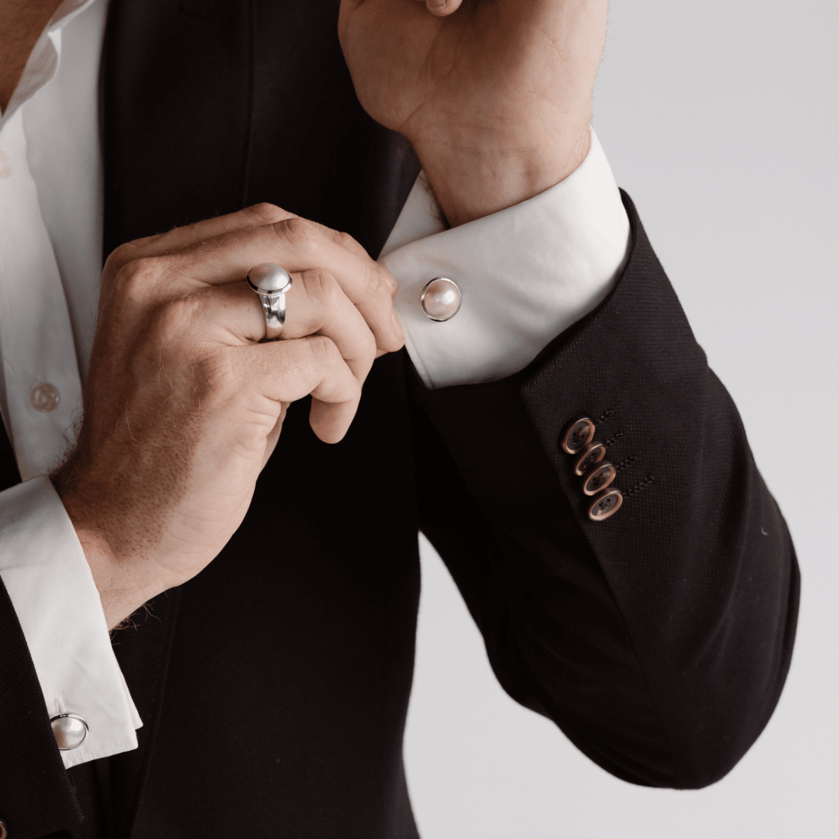 A man wears his Save the Children Pearl Cufflinks featuring Cygnet Bay (WA) grown Australian South Sea Mabe pearls set in sterling silver or gold.