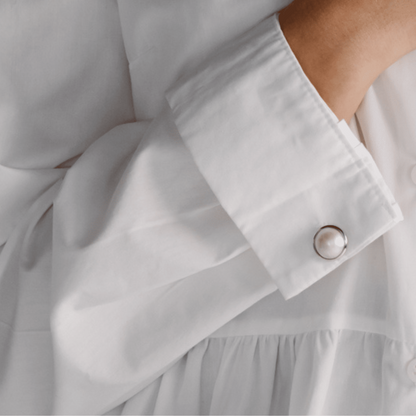 A woman wears her Save the Children Pearl Cufflinks featuring Cygnet Bay (WA) grown Australian South Sea Mabe pearls set in sterling silver or gold.