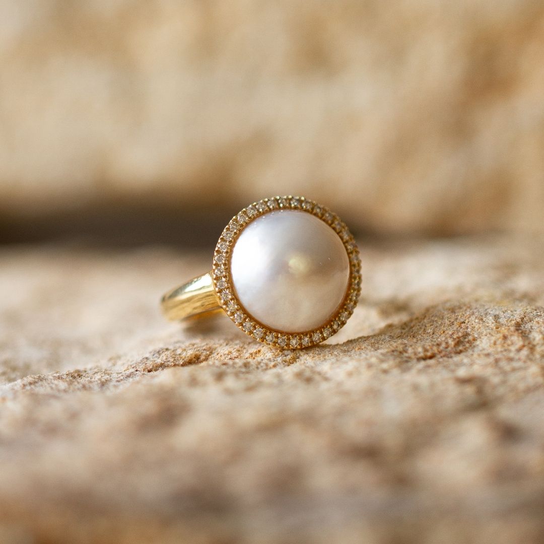 This gorgeous Save the Children Halo Diamond Pearl Ring features a Cygnet Bay (WA) grown Australian South Sea Mabe pearl alongside a halo of White Diamonds set in gold.