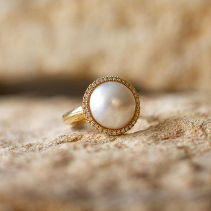 This gorgeous Save the Children Halo Diamond Pearl Ring features a Cygnet Bay (WA) grown Australian South Sea Mabe pearl alongside a halo of White Diamonds set in gold.