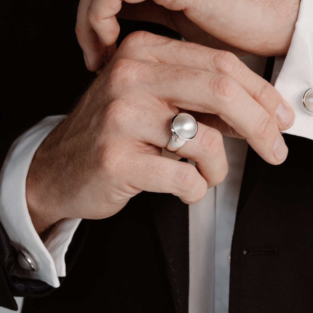 A man wears his Save the Children Pearl Ring featuring a Cygnet Bay (WA) grown Australian South Sea Mabe pearl set in gold or sterling silver.