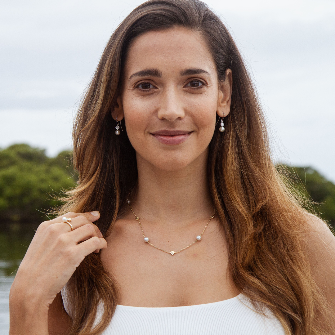 A woman wears her pair of elegant Seagrass Pearl Hook Earrings that feature Broken Bay (NSW) grown Australian Akoya pearls set in gold.