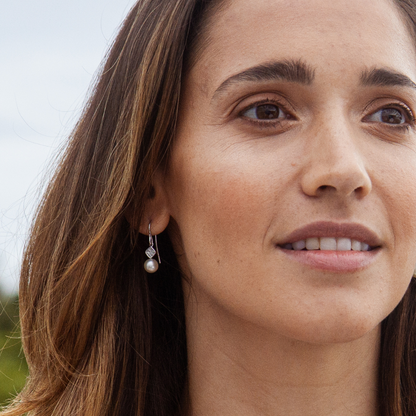 A woman wears her pair of elegant Seagrass Pearl Hook Earrings that feature Broken Bay (NSW) grown Australian Akoya pearls set in gold.