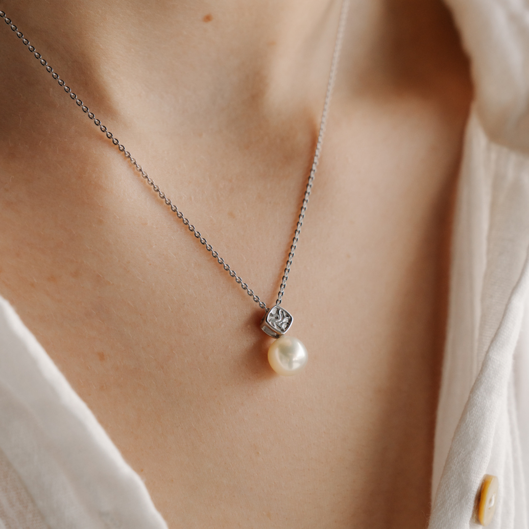 A woman wears her elegant Seagrass Pearl Pendant featuring a Broken Bay (NSW) grown Australian Akoya pearl set in gold.