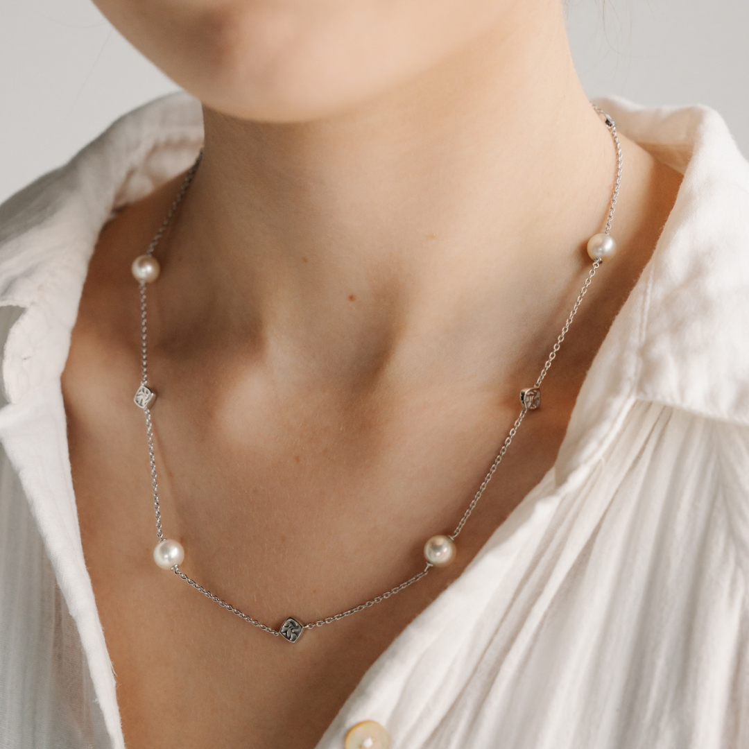 A woman wears her elegant Seagrass Pearl Necklace featuring Broken Bay (NSW) grown Australian Akoya pearls set on a gold chain.