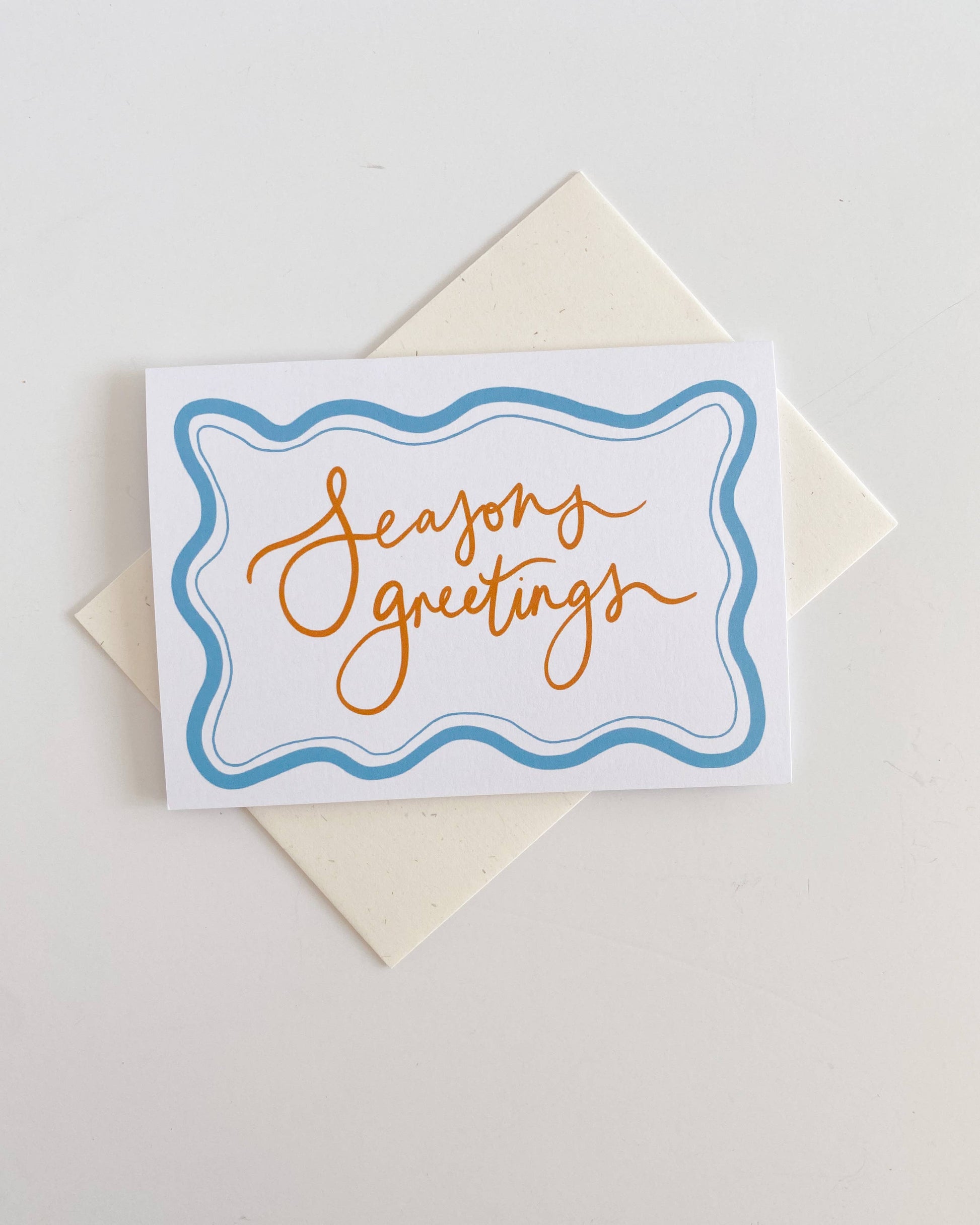 Greeting card with 'Seasons greetings' text on a white background