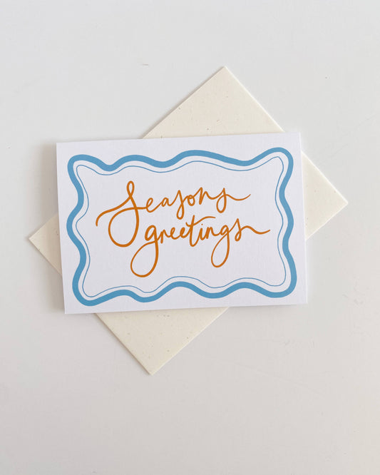 Greeting card with 'Seasons greetings' text on a white background