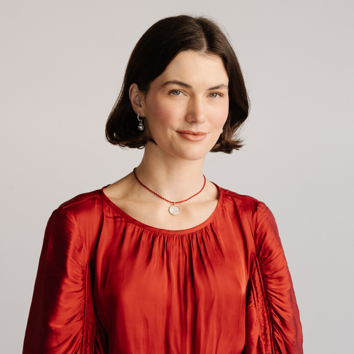 Woman wearing a red blouse against a plain background