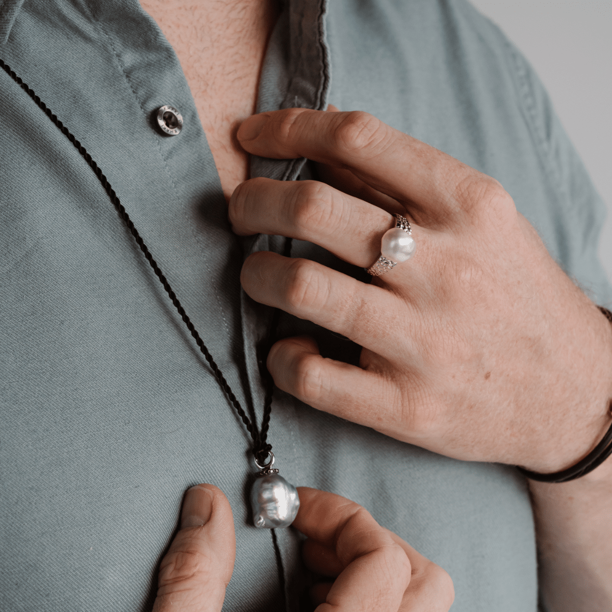 A man wears his versatile 100% Japanese Black Silk Cord Rope with stainless steel end caps, measuring at 100cm long.