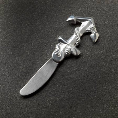 Silver decorative knife with a unique design on a dark background