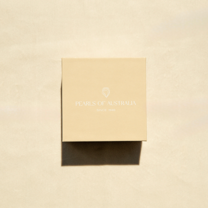 Pearls of Australia gift box on a beige, textured surface.