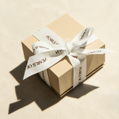 Pearls of Australia gift box with a white ribbon on a beige background