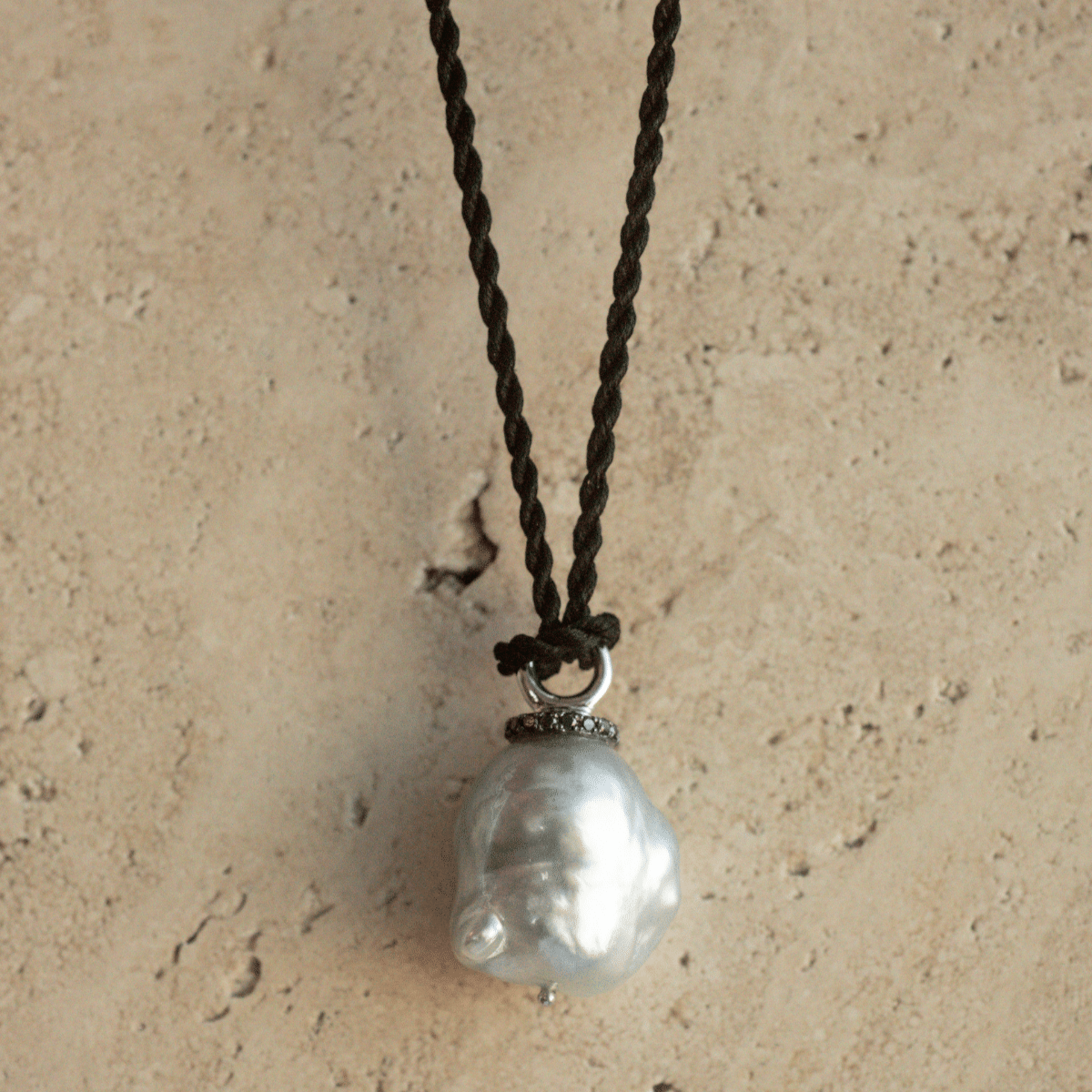 A stunning Stella Pearl Pendant featuring a Cygnet Bay (WA) grown Australian South Sea pearl complemented by 17 Black Diamonds set in gold, delicately hung on a 100% black Silk Cord Rope.