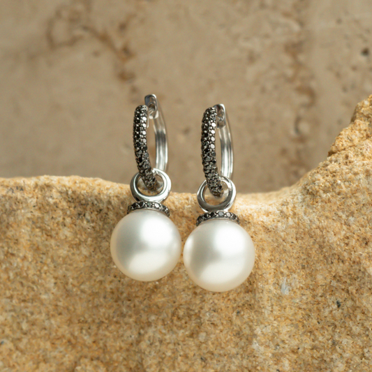 A pair of stunning Stella Petite Pearl Huggie Earrings featuring Cygnet Bay (WA) grown Australian South Sea pearls complemented by 114 Black Diamonds set in gold.