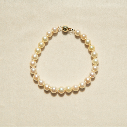 Pearl strand bracelet on a beige background