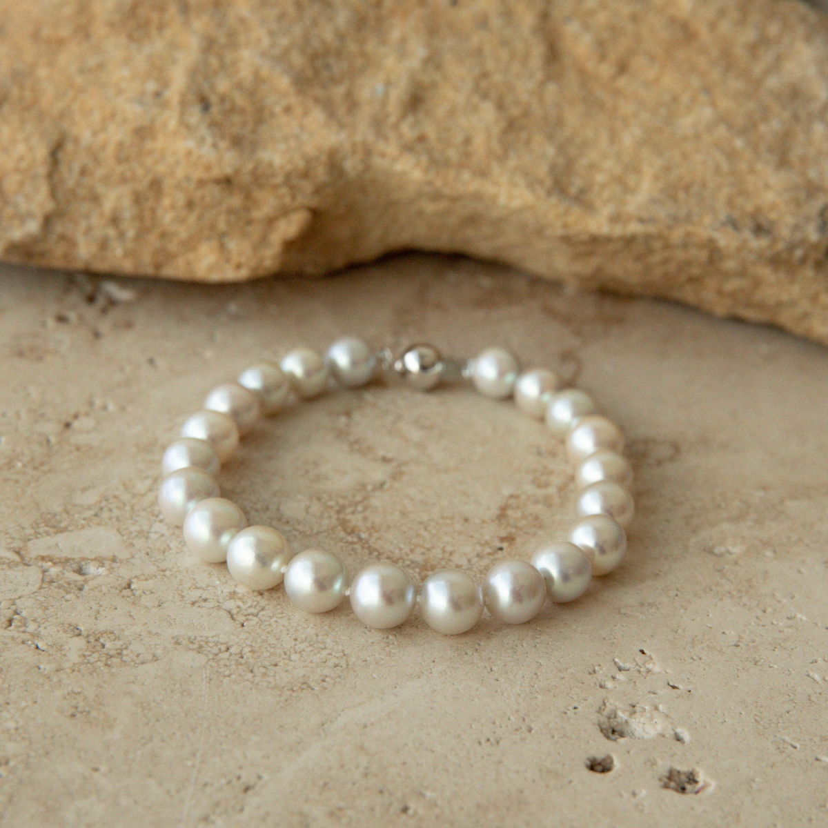 Pearl strand bracelet on a textured stone surface
