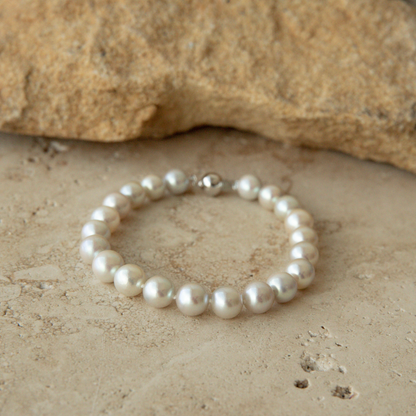 Pearl strand bracelet on a textured stone surface