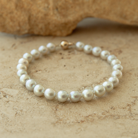 Pearl bracelet on a textured beige surface