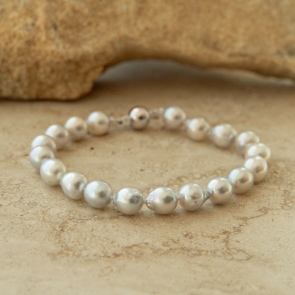Pearl bracelet on a textured beige surface