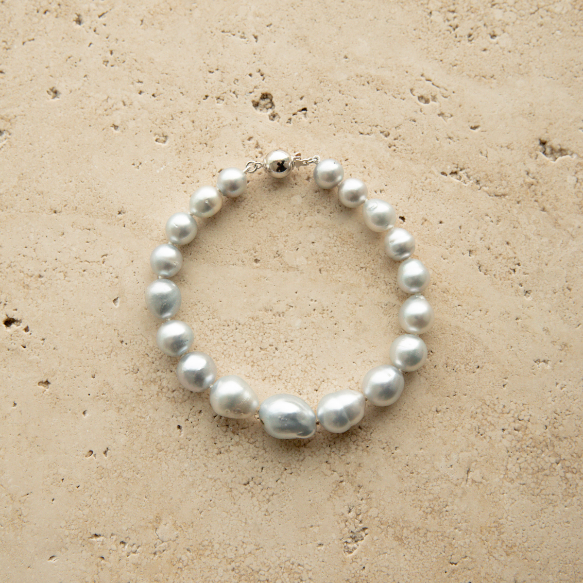 Baroque pearl strand bracelet on a textured stone surface