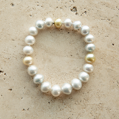 Pearl strand bracelet on a textured beige surface