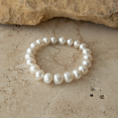 Pearl strand bracelet on a textured stone surface