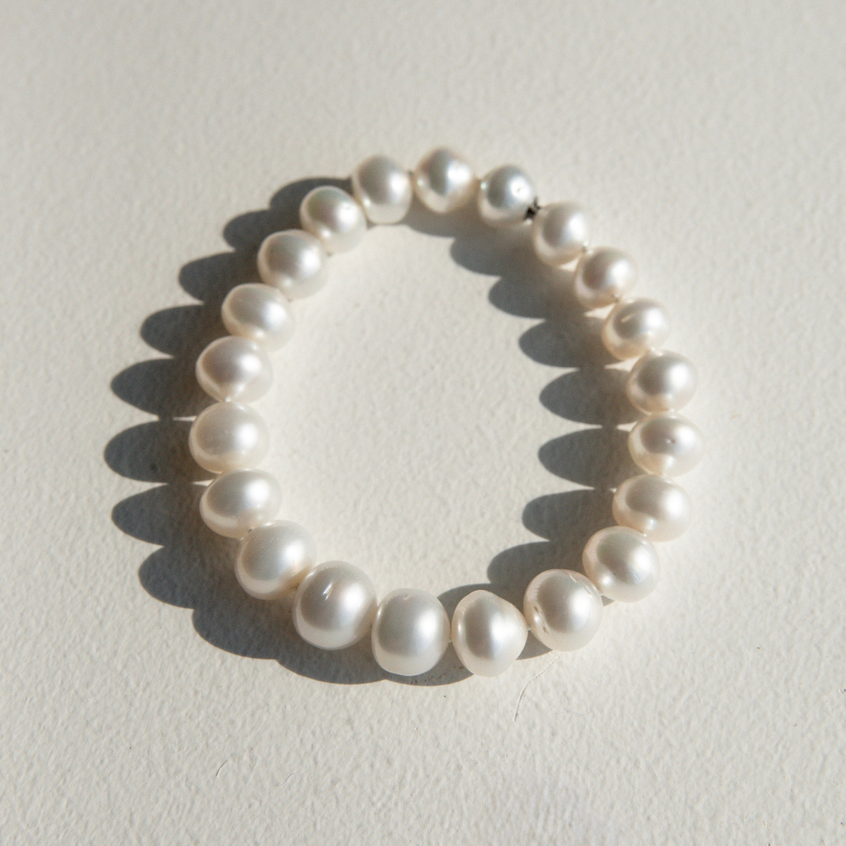 Pearl strand bracelet on a light gray background
