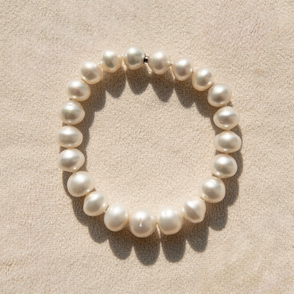 Pearl strand bracelet on a beige background