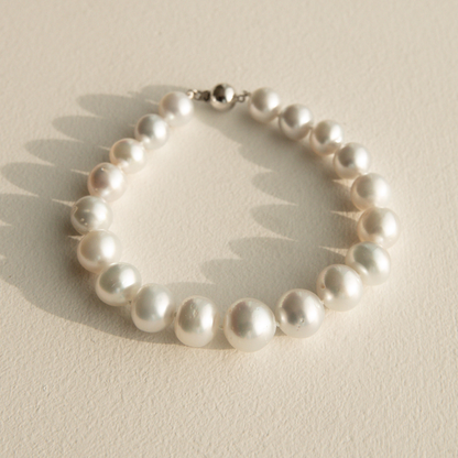 Pearl strand bracelet on a beige background