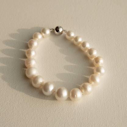Pearl strand bracelet on a light beige background