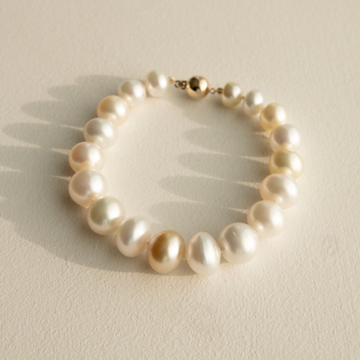 Multicolour pearl strand bracelet on a beige background