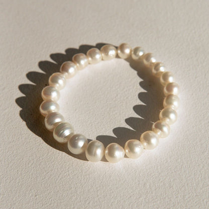 Australia South Sea pearls, arranged in a circle on a textured beige surface with a soft shadow.