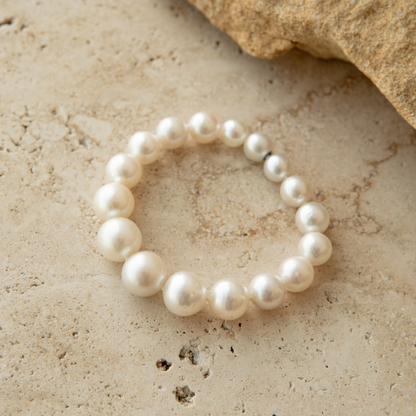 South Sea pearl strand bracelet on a textured beige surface