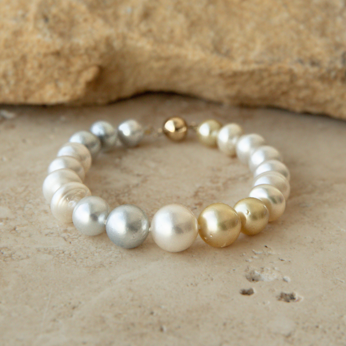 Pearl strand bracelet on a textured beige surface