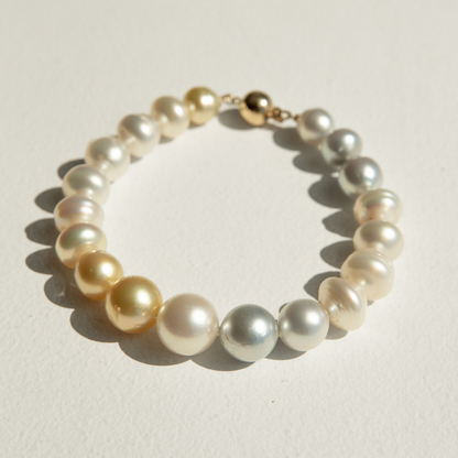 Pearl strand bracelet with gold clasp on a light background