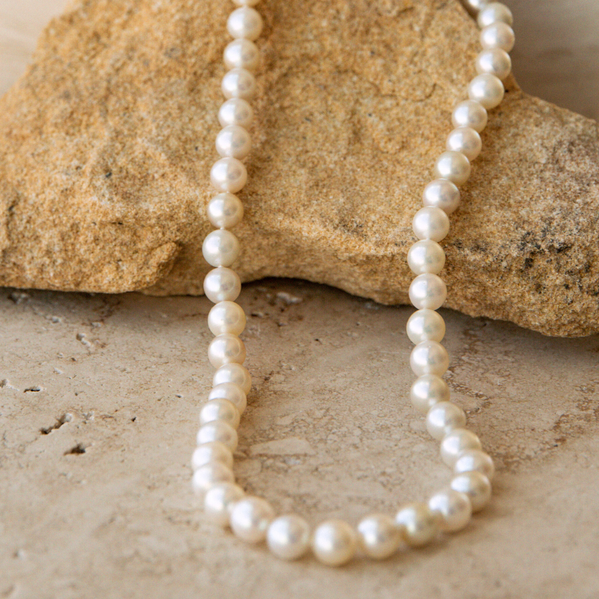 Pearl strand necklace on a stone surface