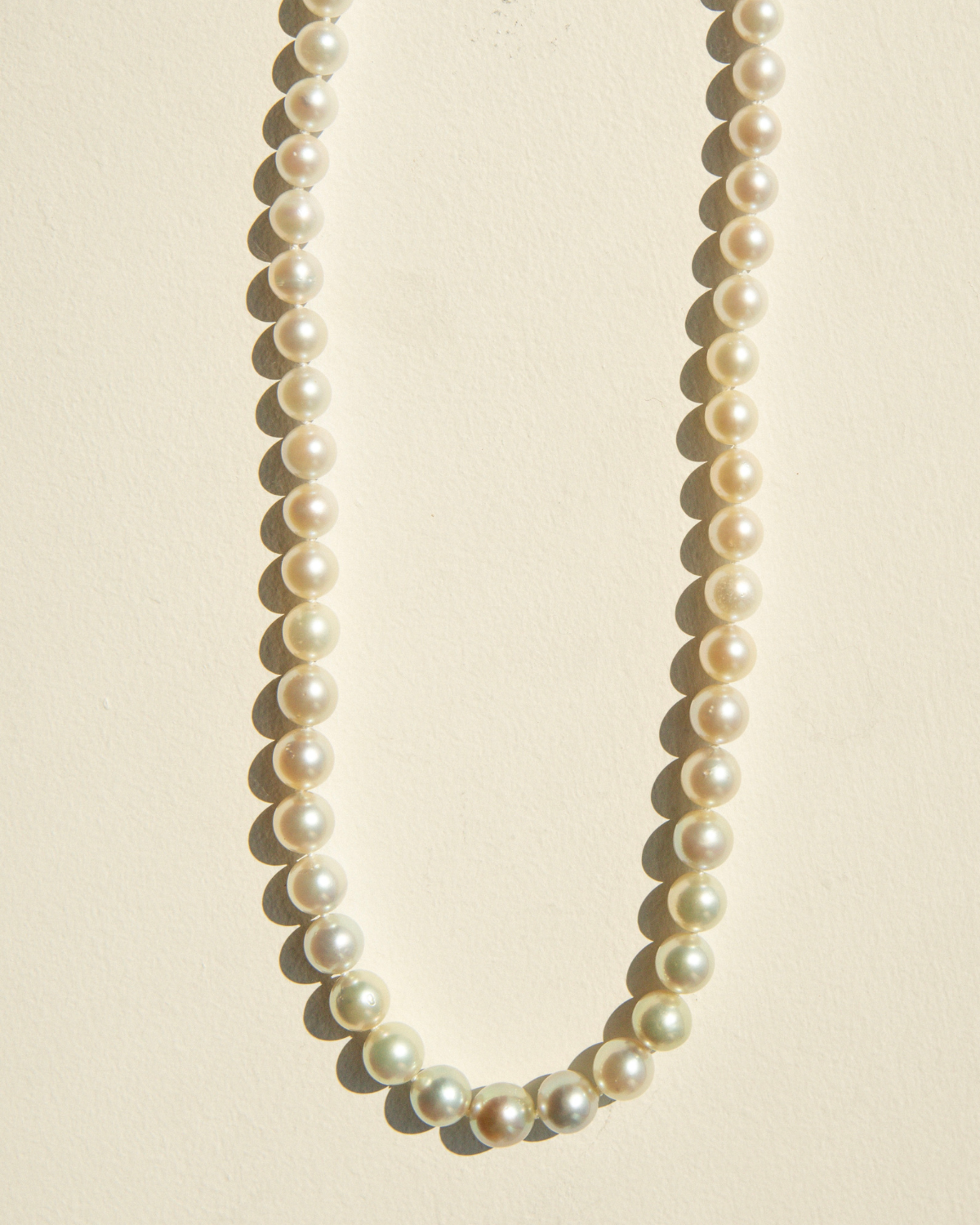 Pearl necklace on a beige background
