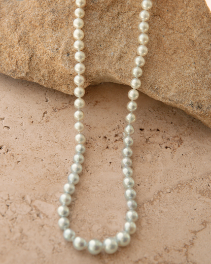Pearl necklace on a textured stone surface