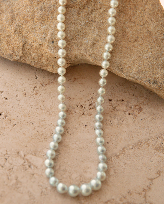 Pearl necklace on a textured stone surface