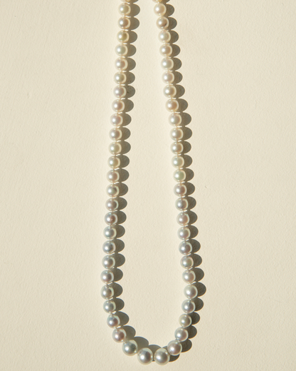 Pearl necklace on a beige background