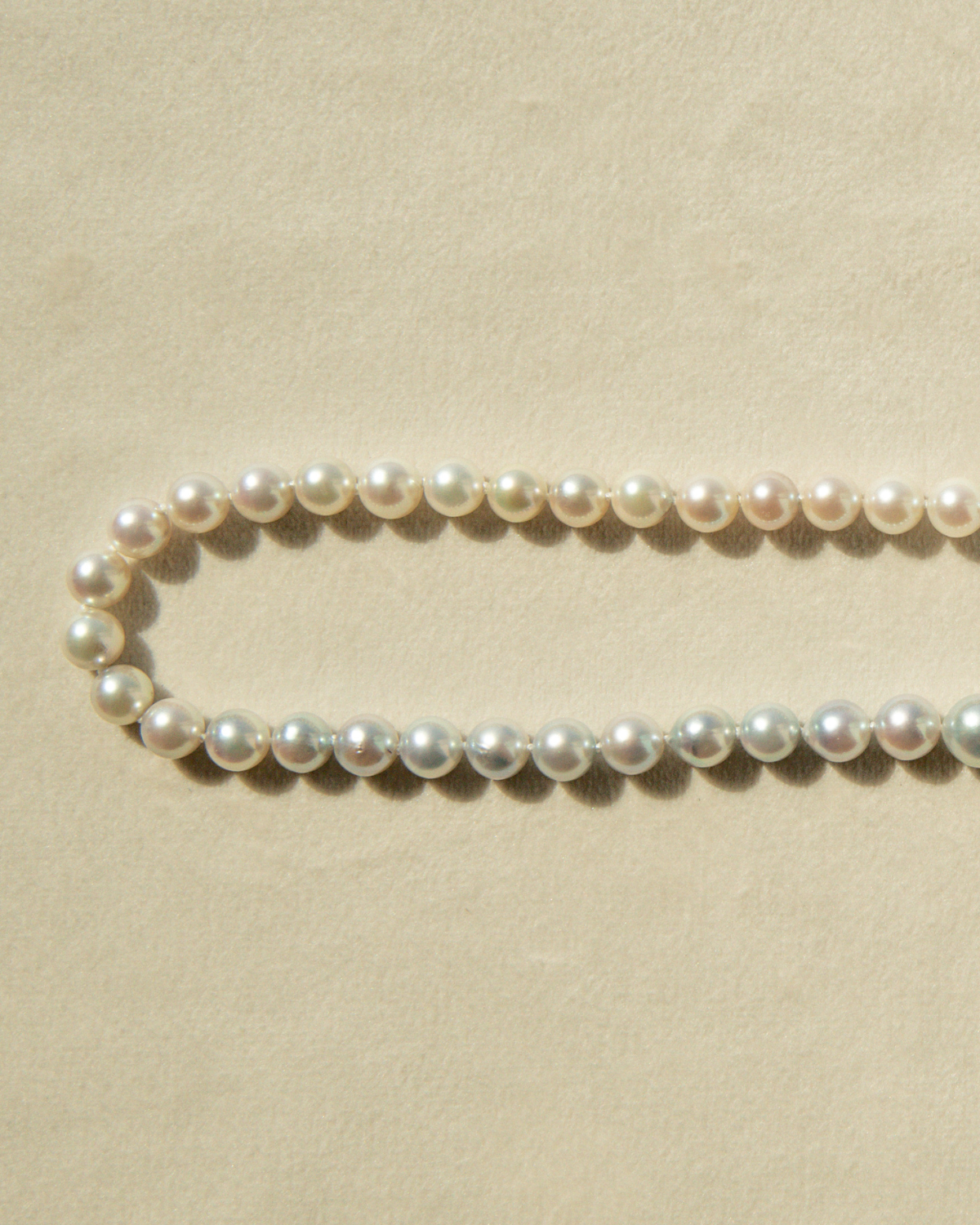 Pearl necklace on a beige background