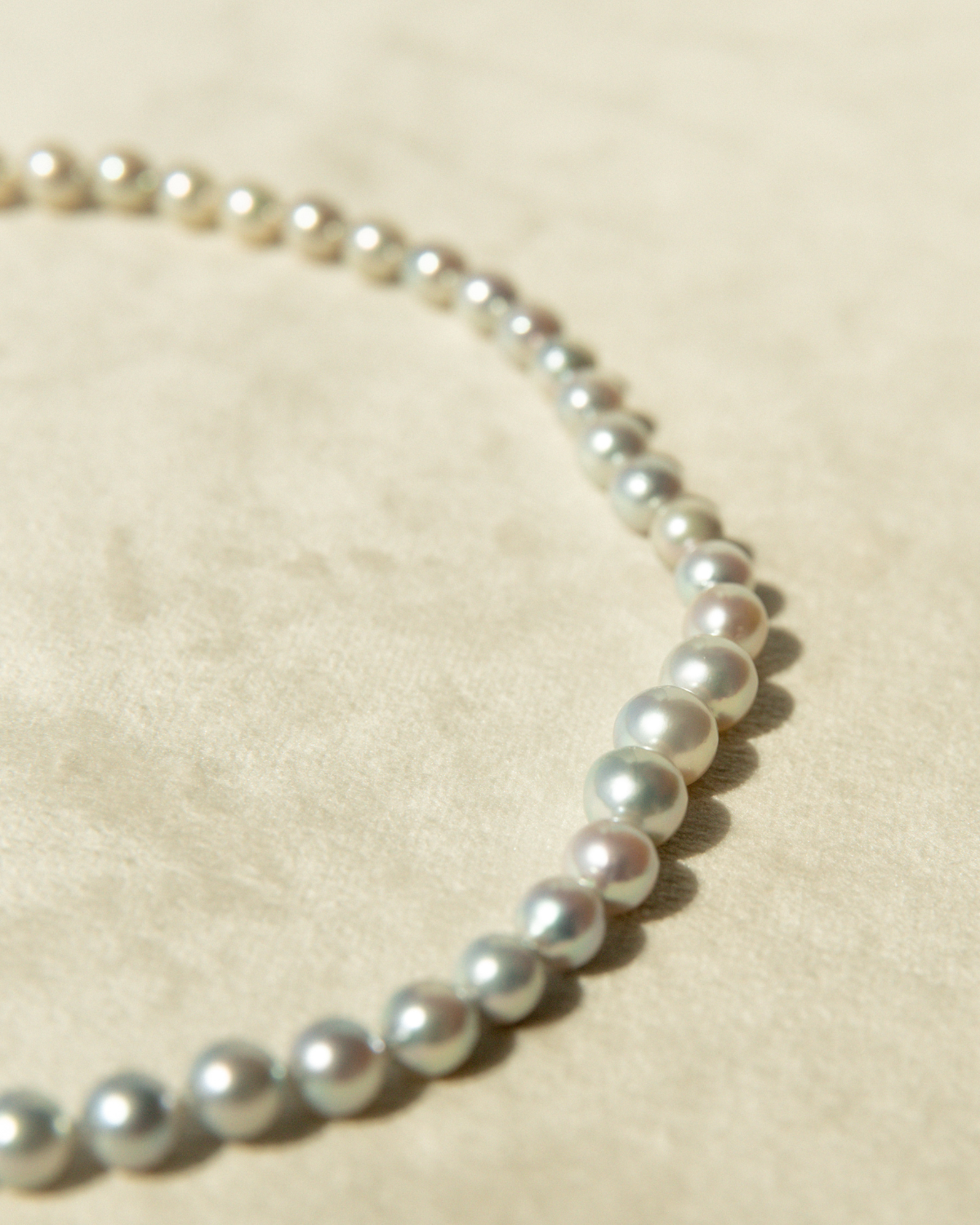 Pearl necklace on a beige fabric background
